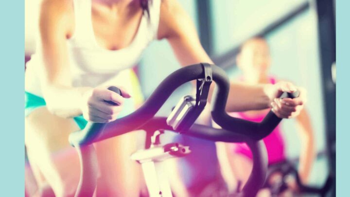 woman on spin bike colorful background