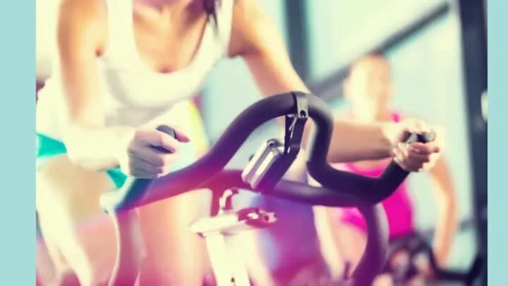 woman on spin bike colorful background