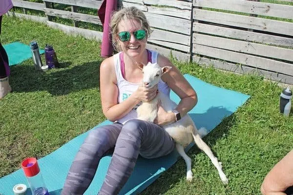 woman and baby goat at yoga