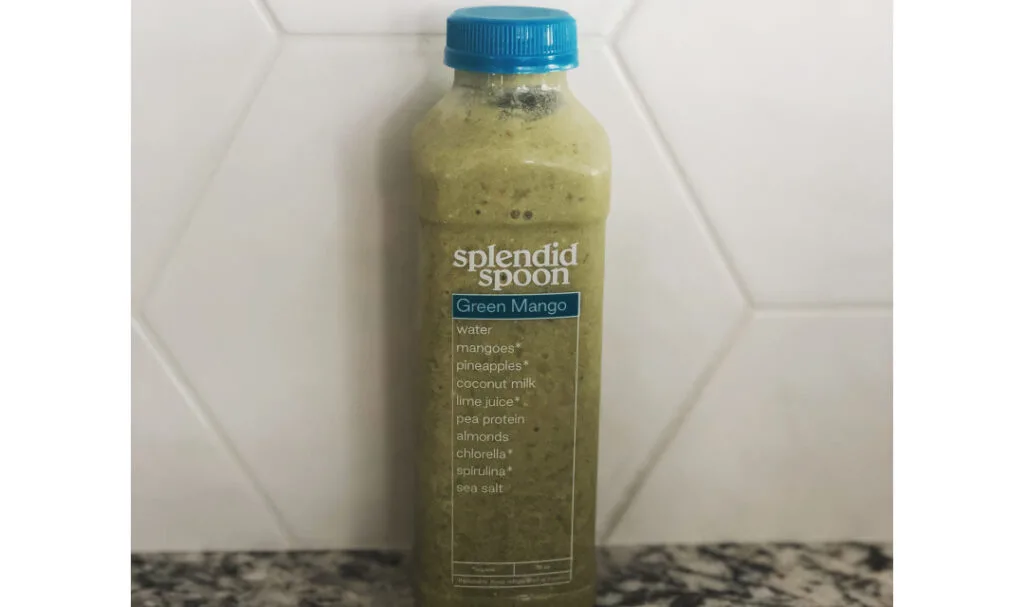 Splendid green mango smoothie against a white backsplash