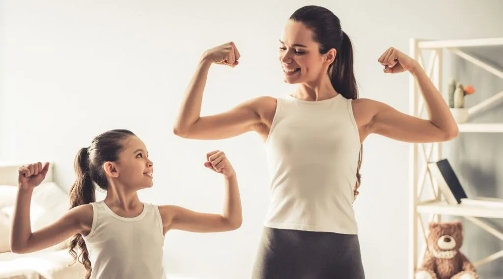 mom and daughter flexing muscles