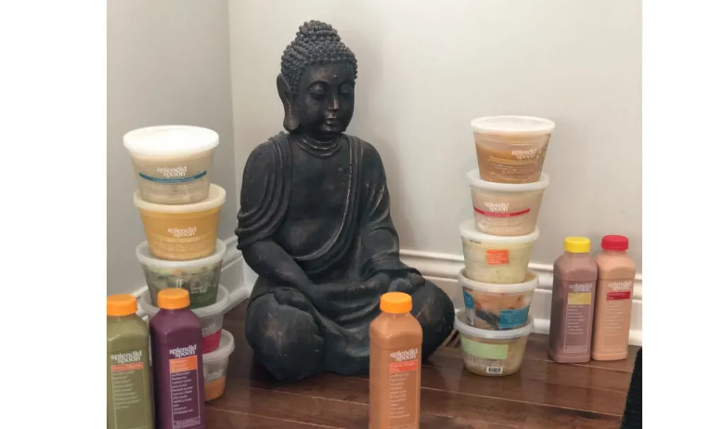 buddha statue surrounded by Splendid Spoon bowls and smoothies