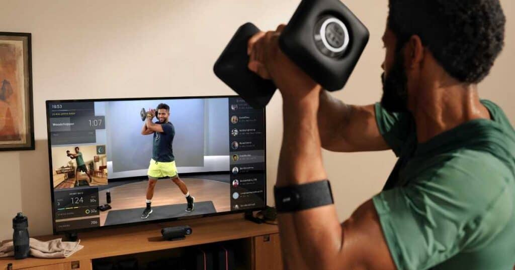 man lifting weight in front of TV