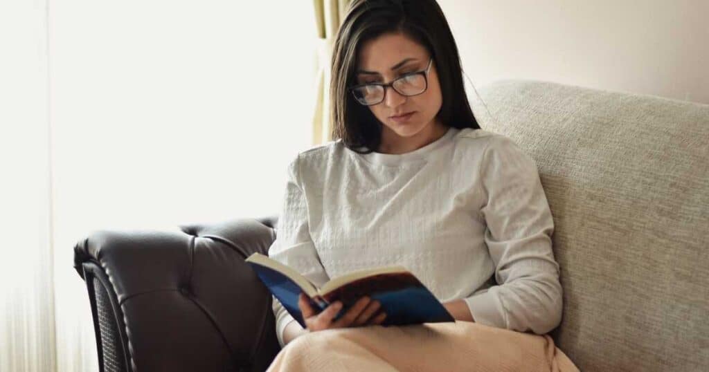 woman on couch reading book