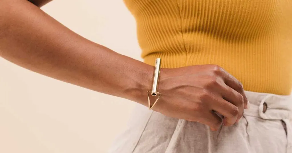 woman wearing Komuso gold cuff bracelet and gold shirt