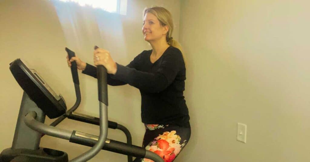 woman wearing flowered pants on elliptical