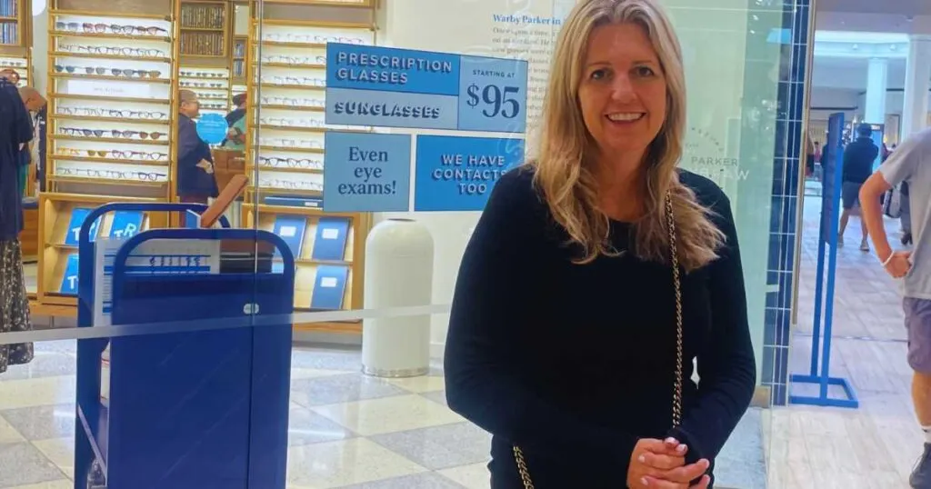 Michelle Platt standing in front of Warby Parker signs