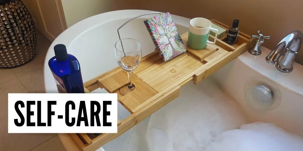 bathtub with bubbles wooden tray mug whine glass kindle and text overlay self care