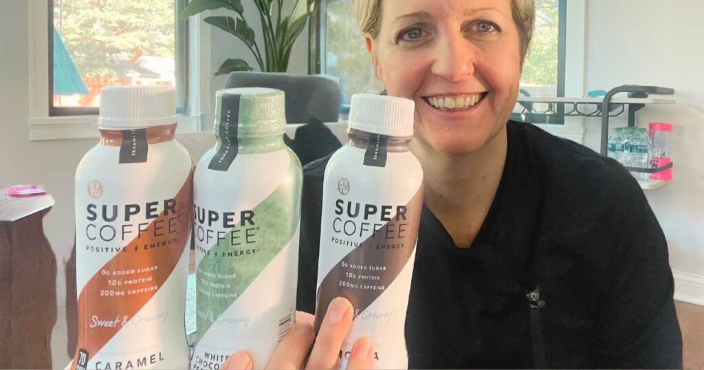 woman holding 3 bottles of super coffee flavors