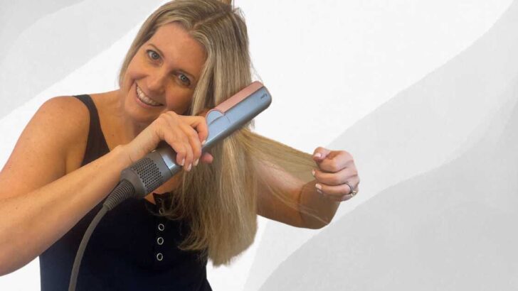 gray background woman using dyson airstrait