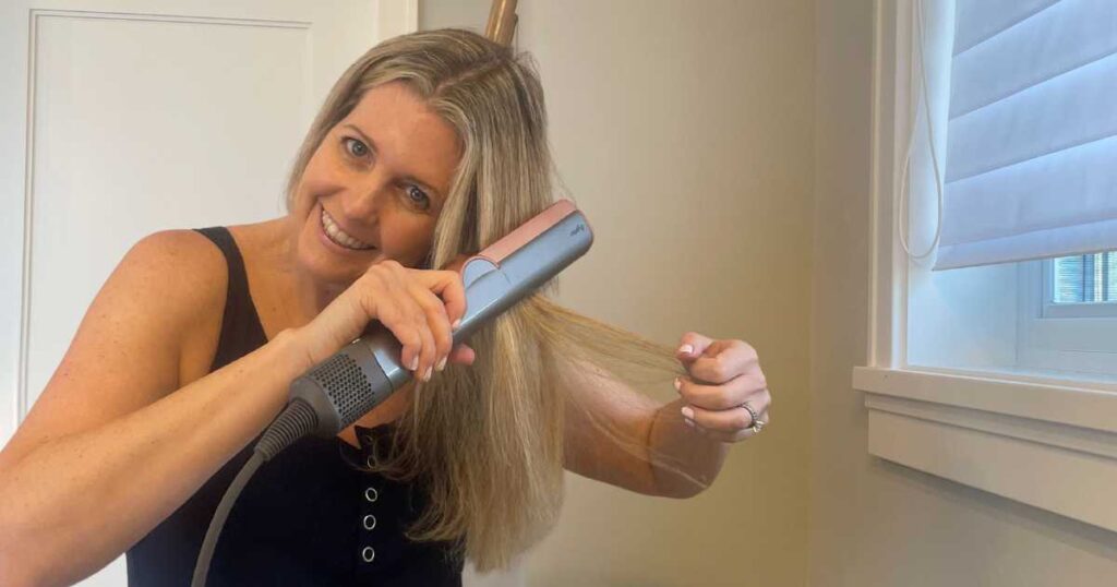 michelle platt using the dyson airstrait in front of a window