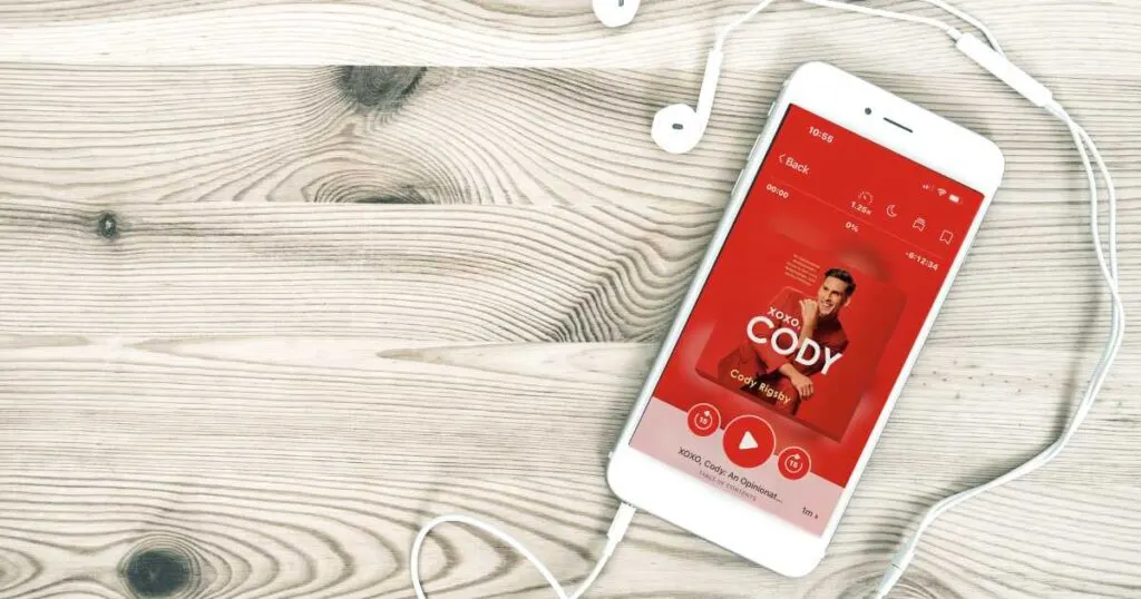 iphone showing red cover of cody rigsby''s audiobook with headphones