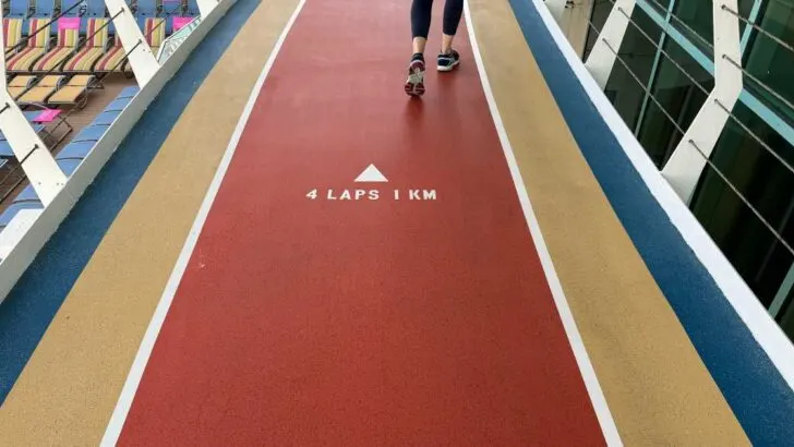 red walking path on royal caribbean freedom of hte seas ship with lounge chairs in background