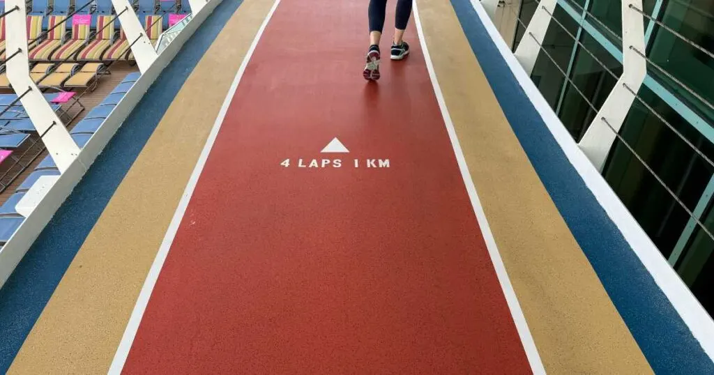 woman's feet on walking path on royal caribbean ship with lounge chairs below