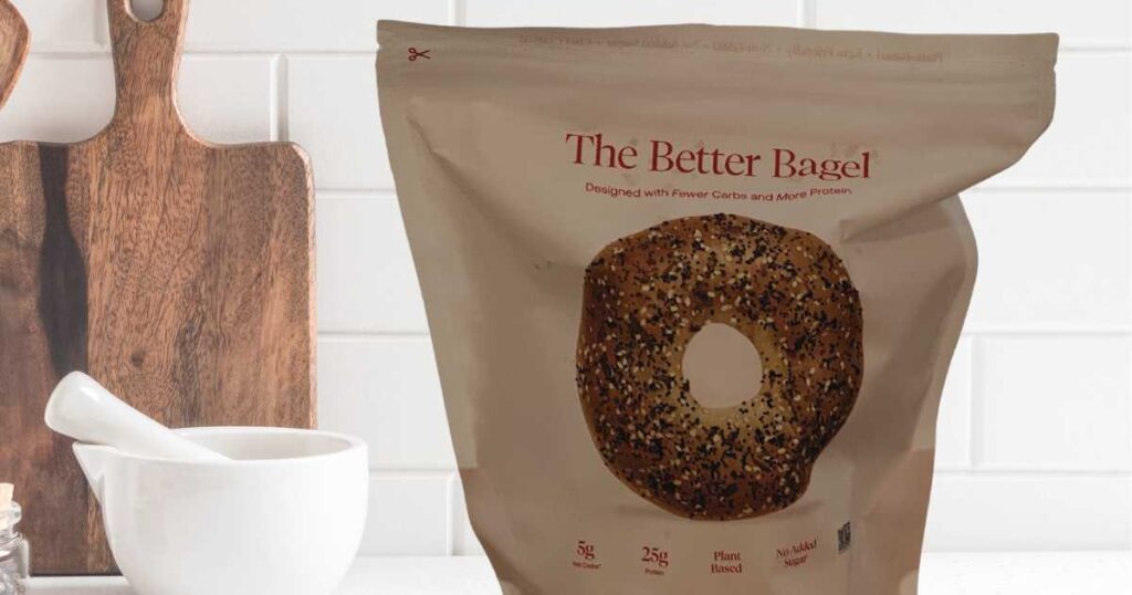 the better bagel packaging sitting in front of a white tile kitchen backsplash next to a wooden cutting board and a mixing bowl.