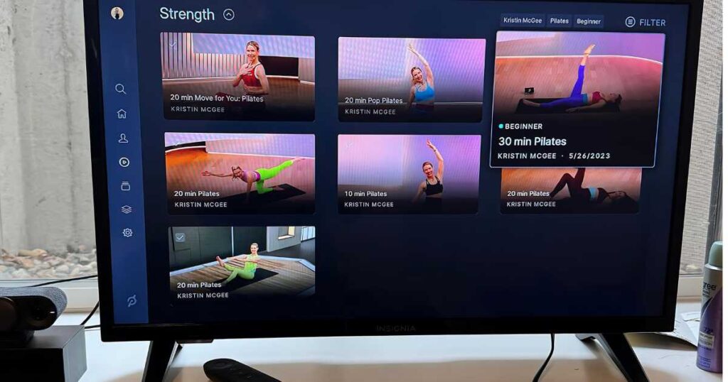 Peloton Guide showing Peloton Pilates workouts on a television.