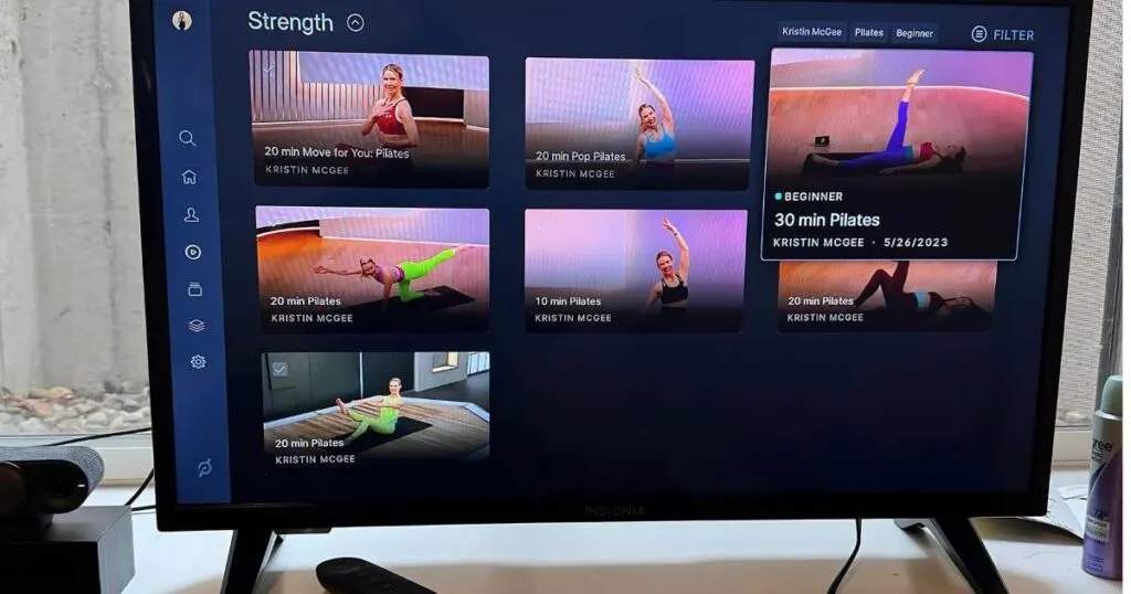 Peloton Guide showing Peloton Pilates workouts on a television.