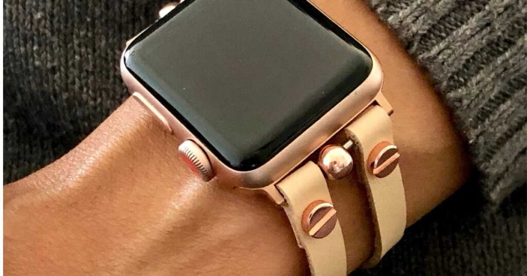vegan leather light beige and rose gold hardware apple watch band on woman's wrist.