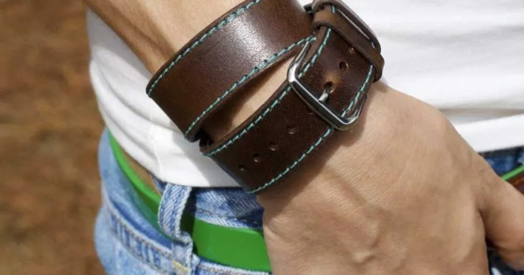 double wrap brown leather watch band on wrist white t-shirt.