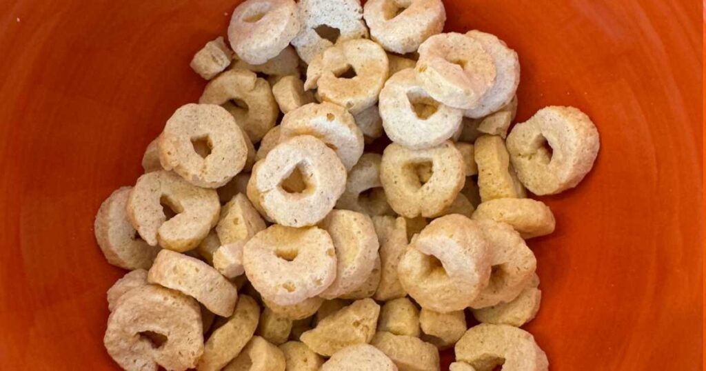 Orange background Three WIshes cereal Os in bowl.